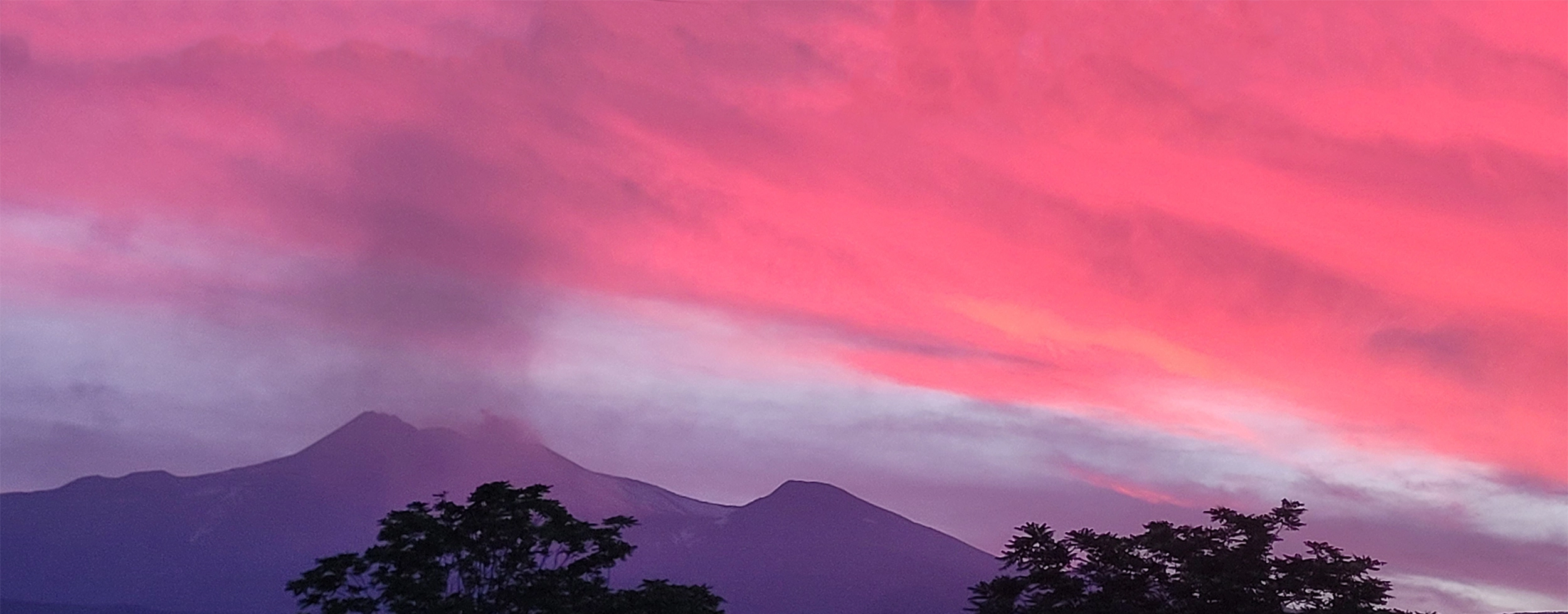 Sunset over Mount Etna with volcanic craters and dark lava landscape